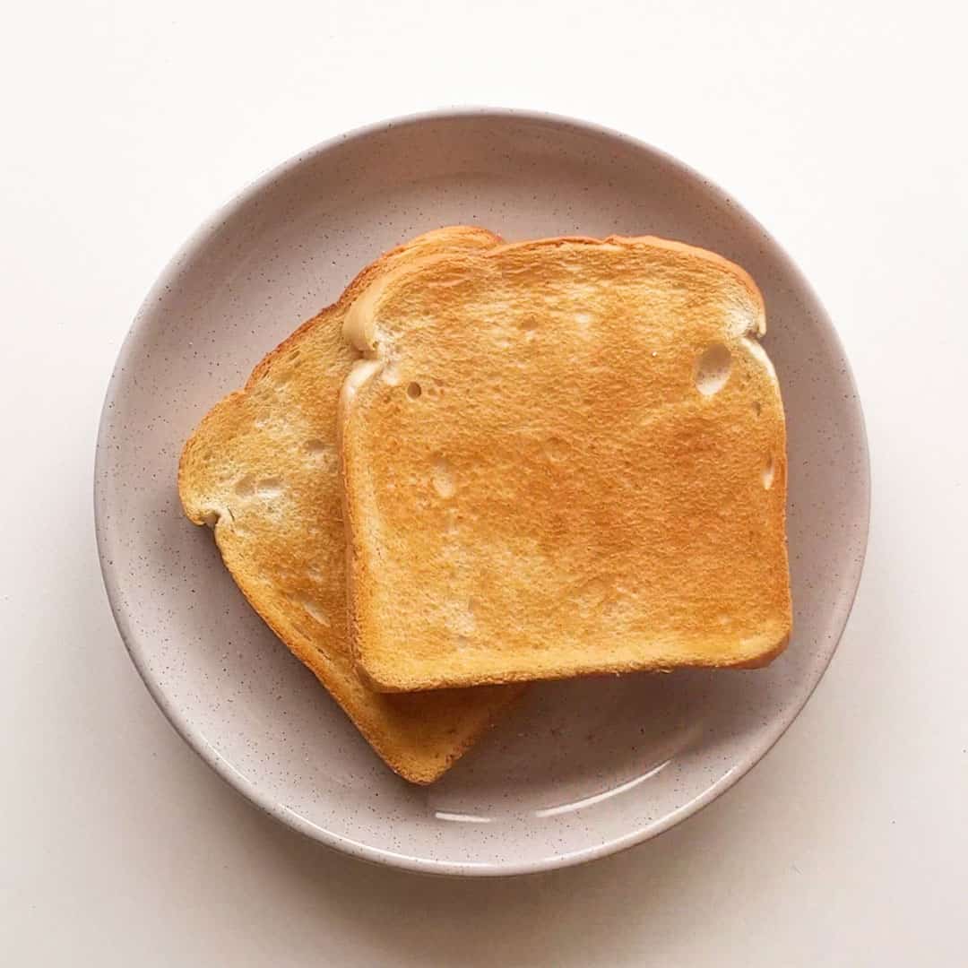 Two slices of toasted white bread on a grey plate.