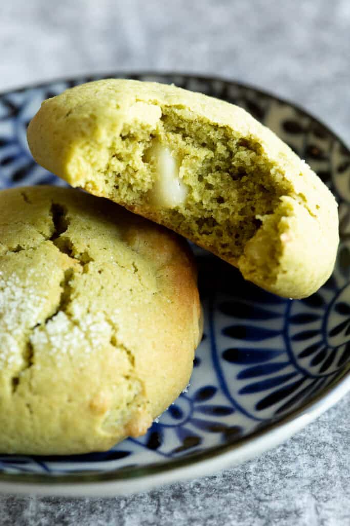 Two green matcha cookies on a small blue plate.