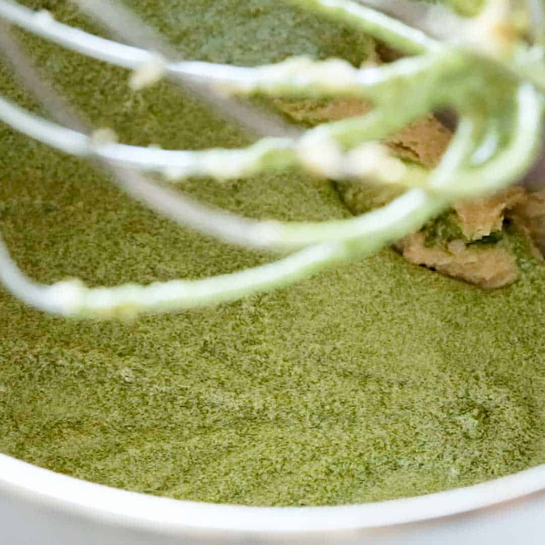 Mixing the matcha tea mix into the creamed sugar and butter.