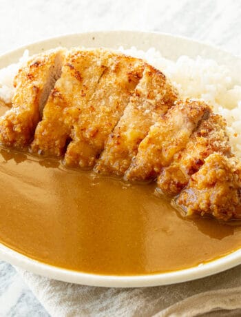 A sliced pork cutlet on sushi rice with curry sauce.