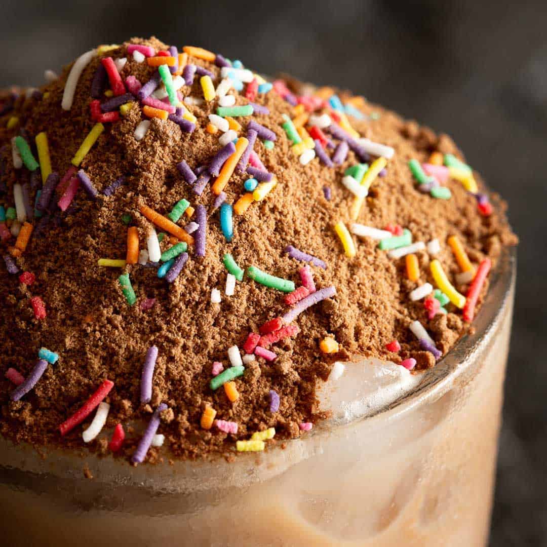 A glass of iced malt chocolate with sprinkles.