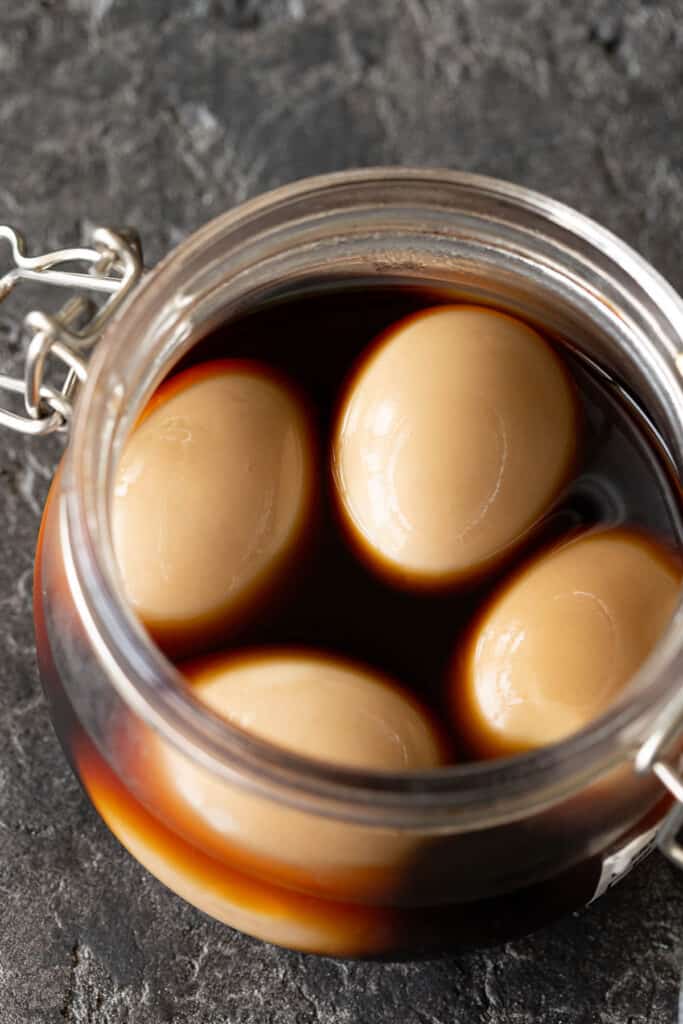 Ramen eggs in a soy sauce marinade in a jar.