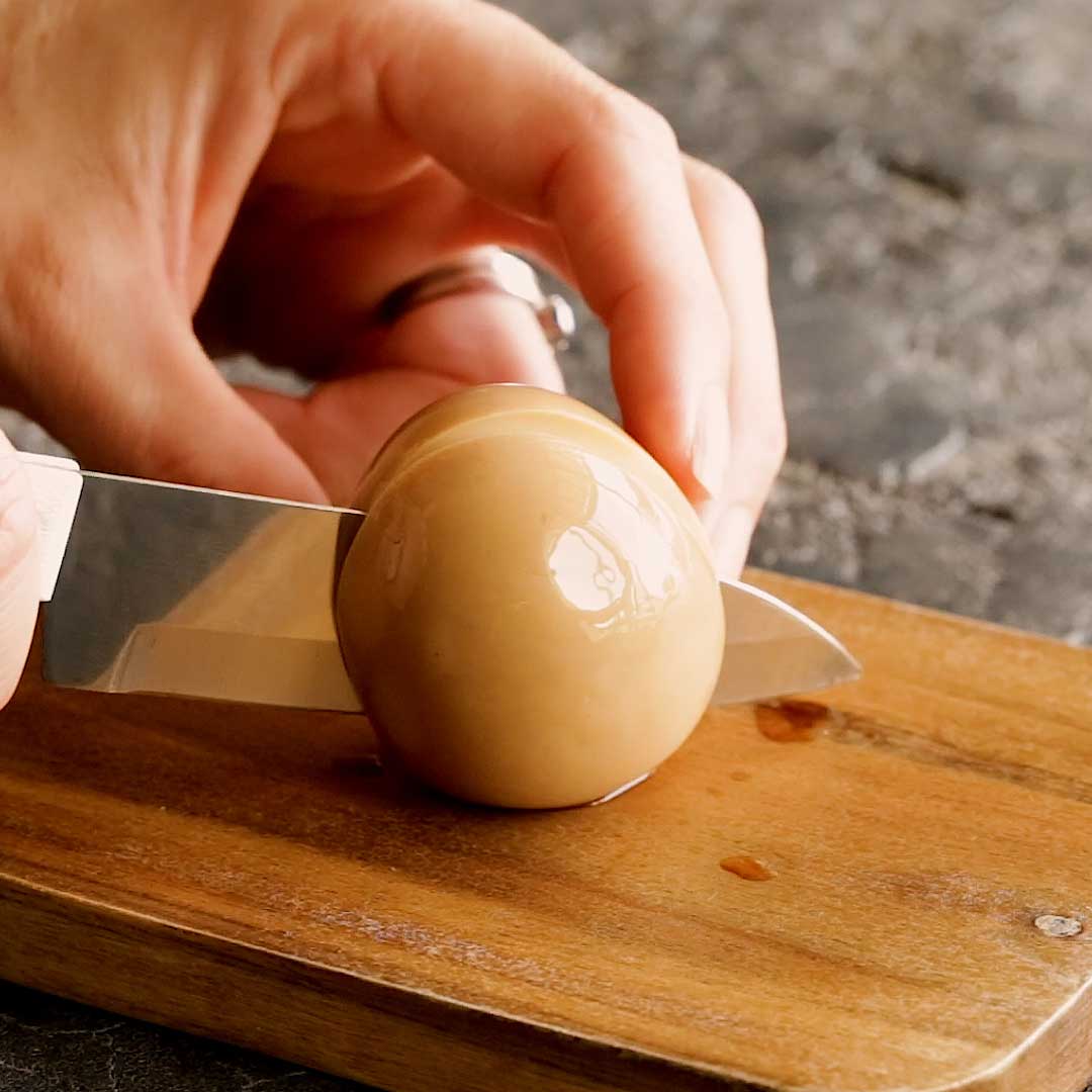 Slicing the ramen egg with a knife.
