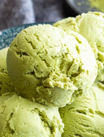 Bowl of green, creamy matcha ice cream scoops.