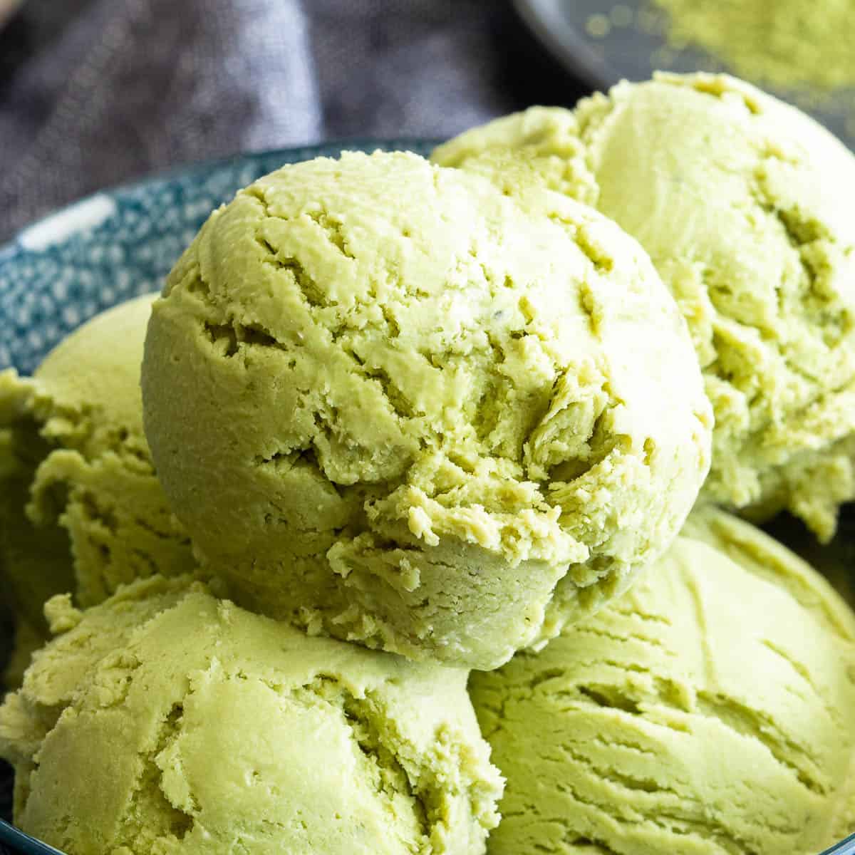 Bowl of green, creamy matcha ice cream scoops.