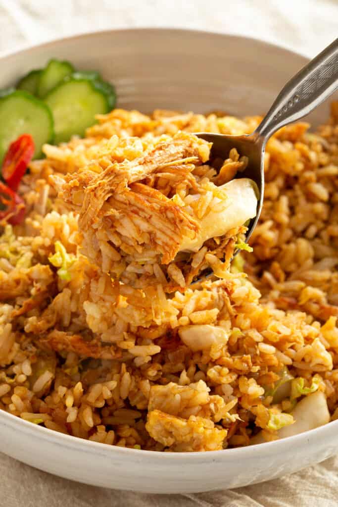 A spoonful of Nasi Goreng with sambal chicken and cabbage.
