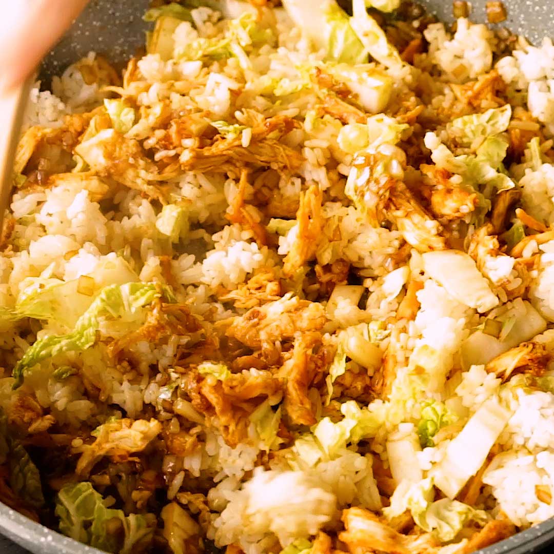 Tossing the Indonesian fried rice together in a frying pan.