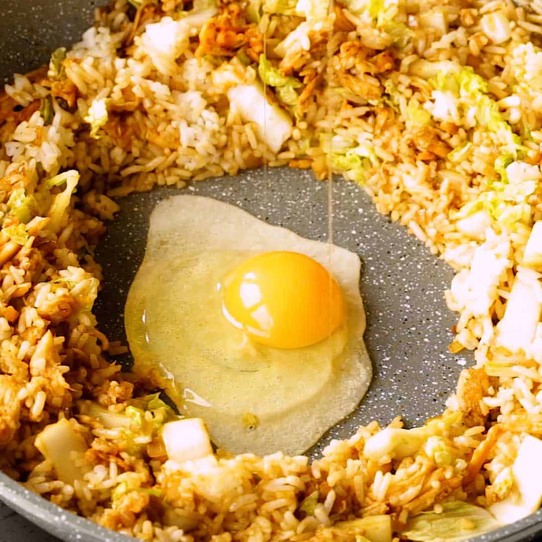 Cracking an egg into the centre of the nasi goreng.