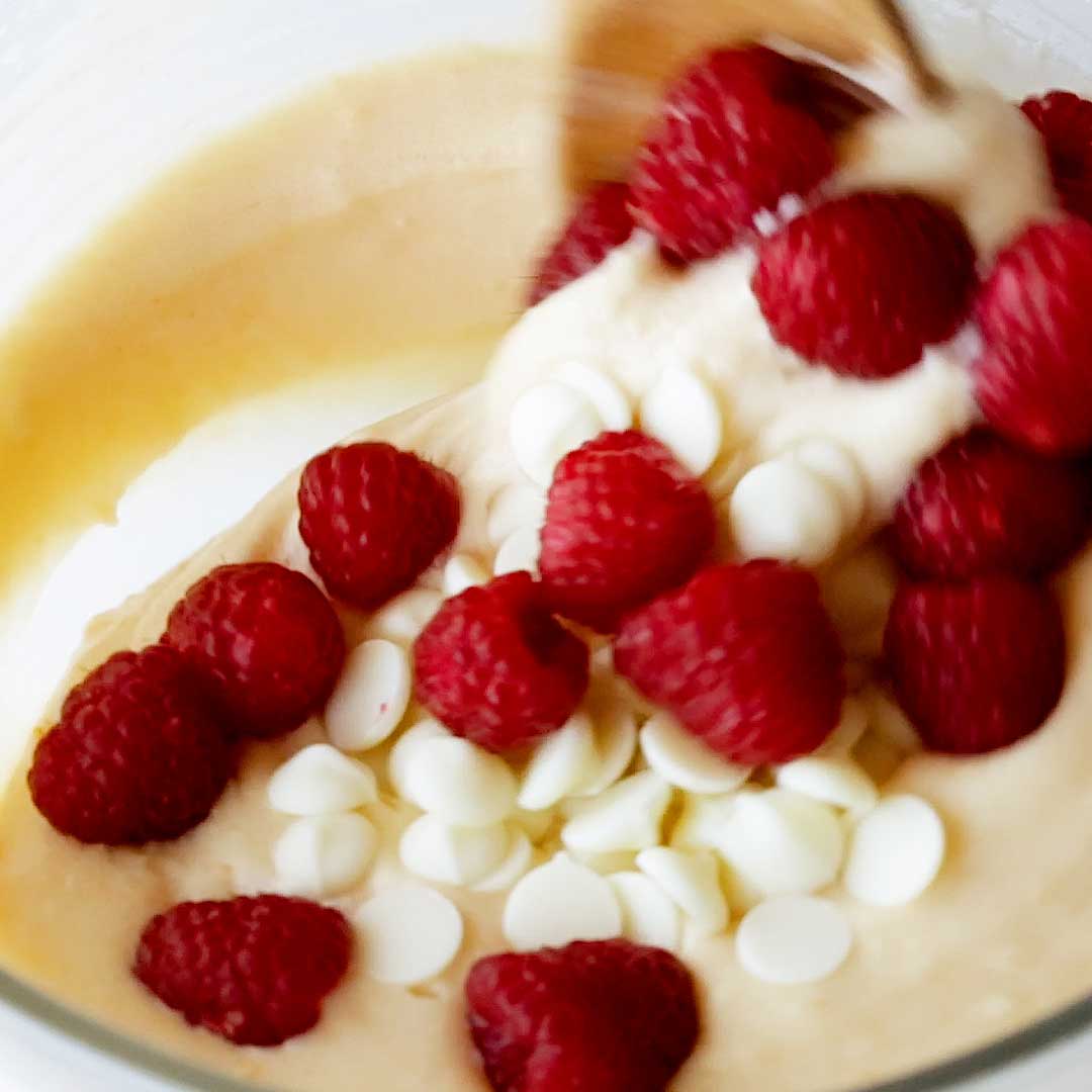 Pouring in fresh raspberries and white chocolate.