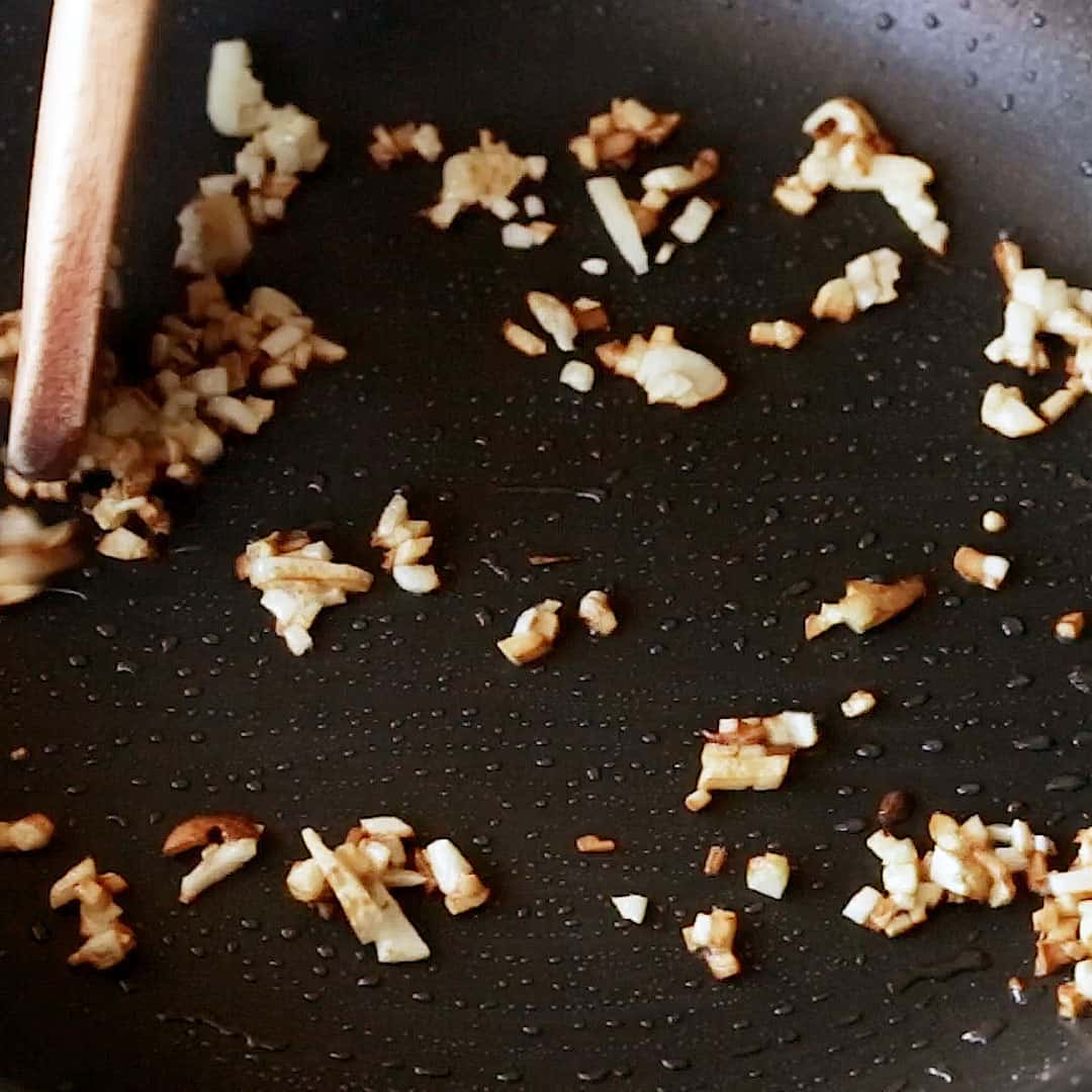 Frying garlic in a frying pan until crispy.