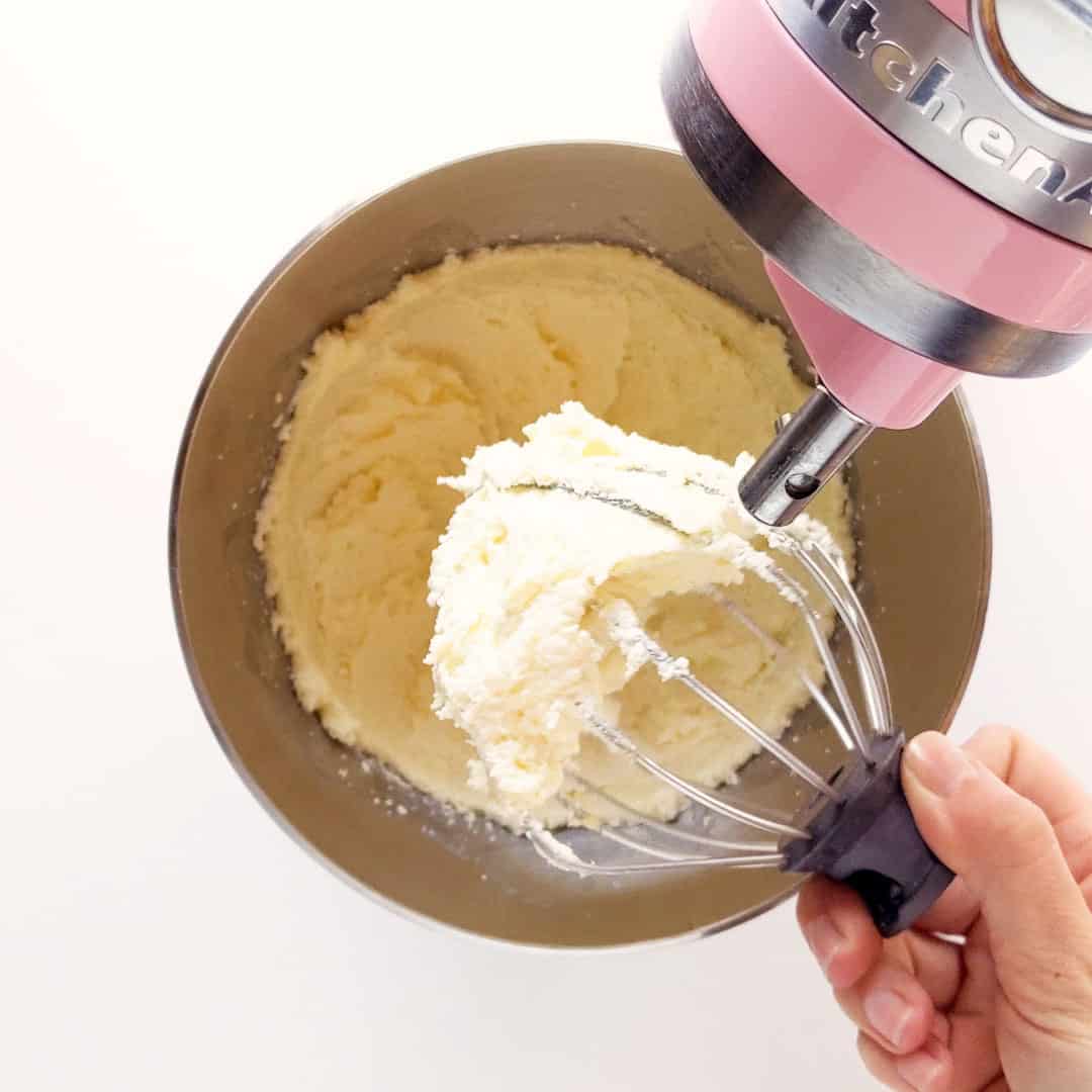A stand mixer showing the creamed butter and sugar.