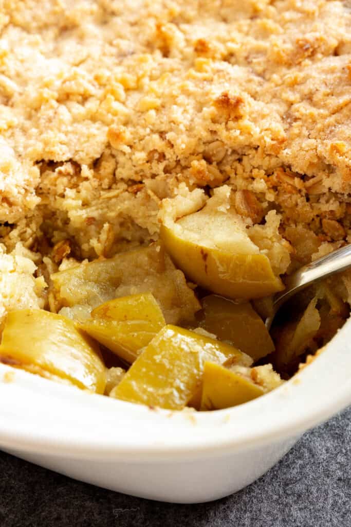 A spoon scoops out cinnamon-spiced apples.