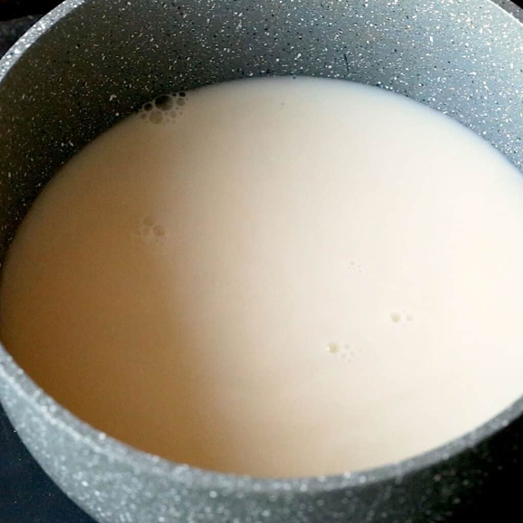 A saucepan filled with soy milk and chicken stock, ready to be warmed through.