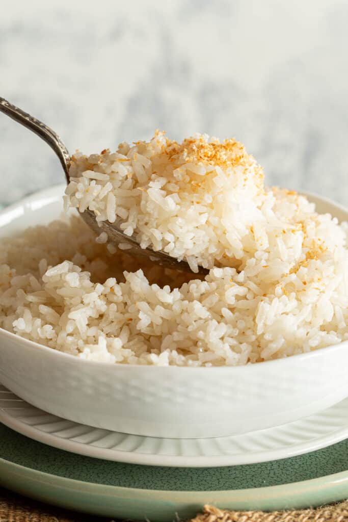 A spoon scoops up a heap of creamy coconut rice.