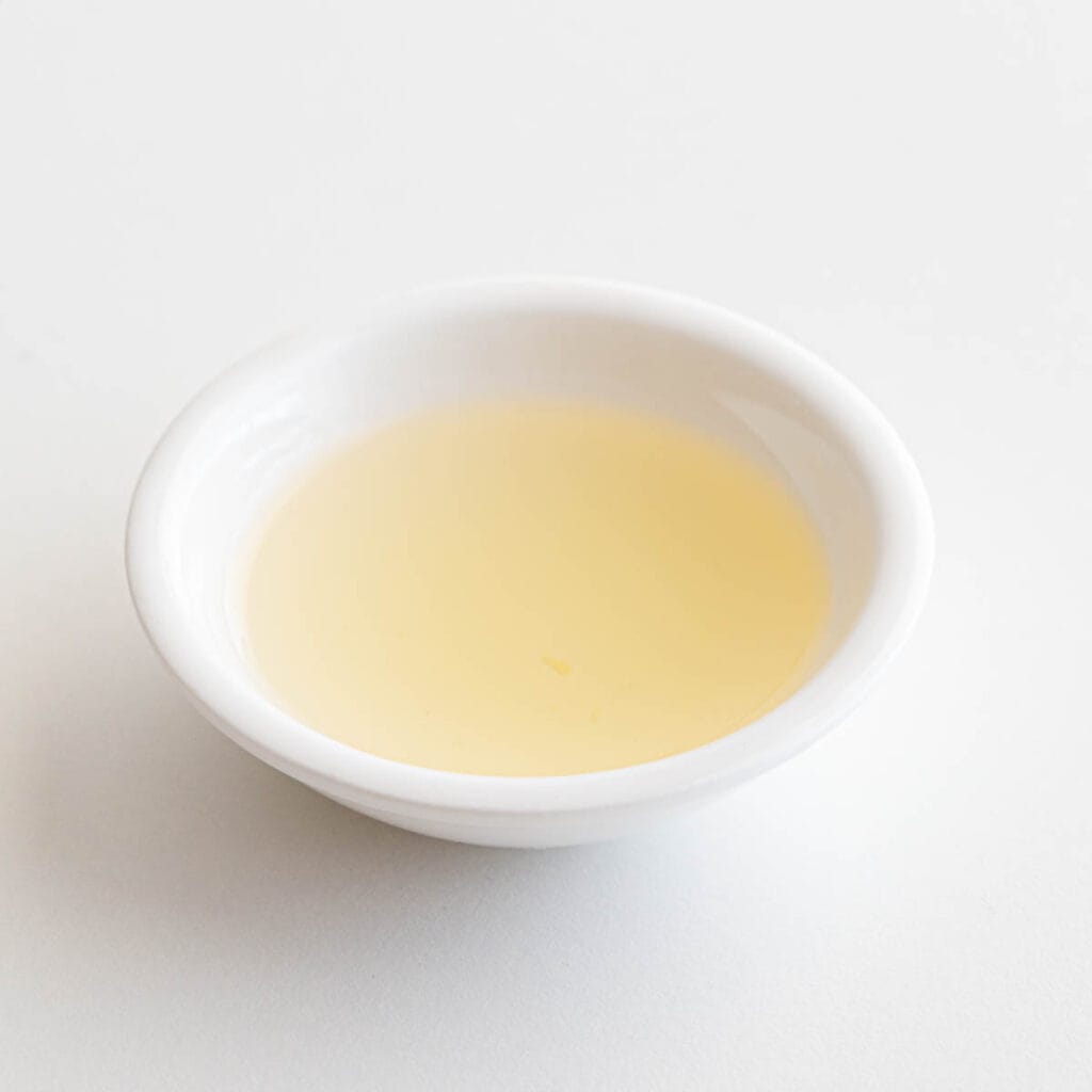 Small white dish filled with cooking sake.
