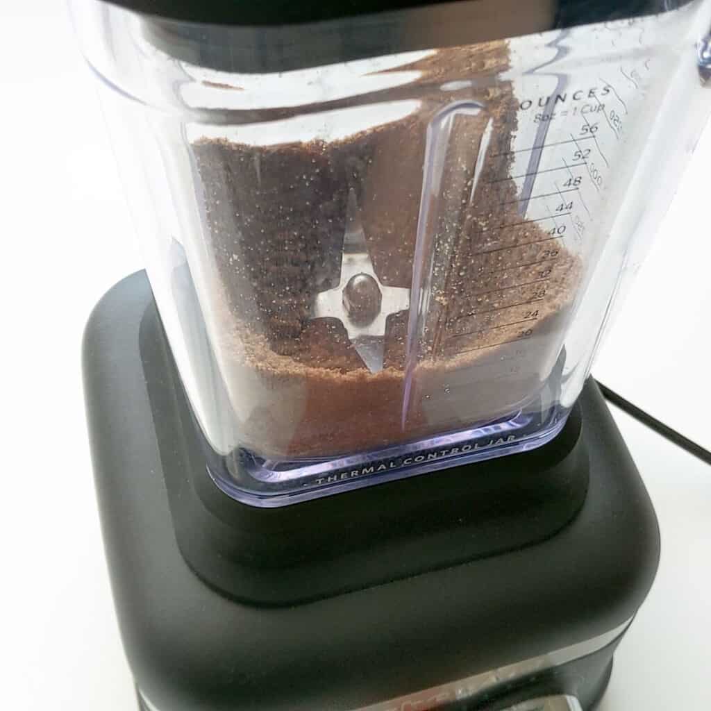 A blender crushes spiced speculoos biscuits to powder.