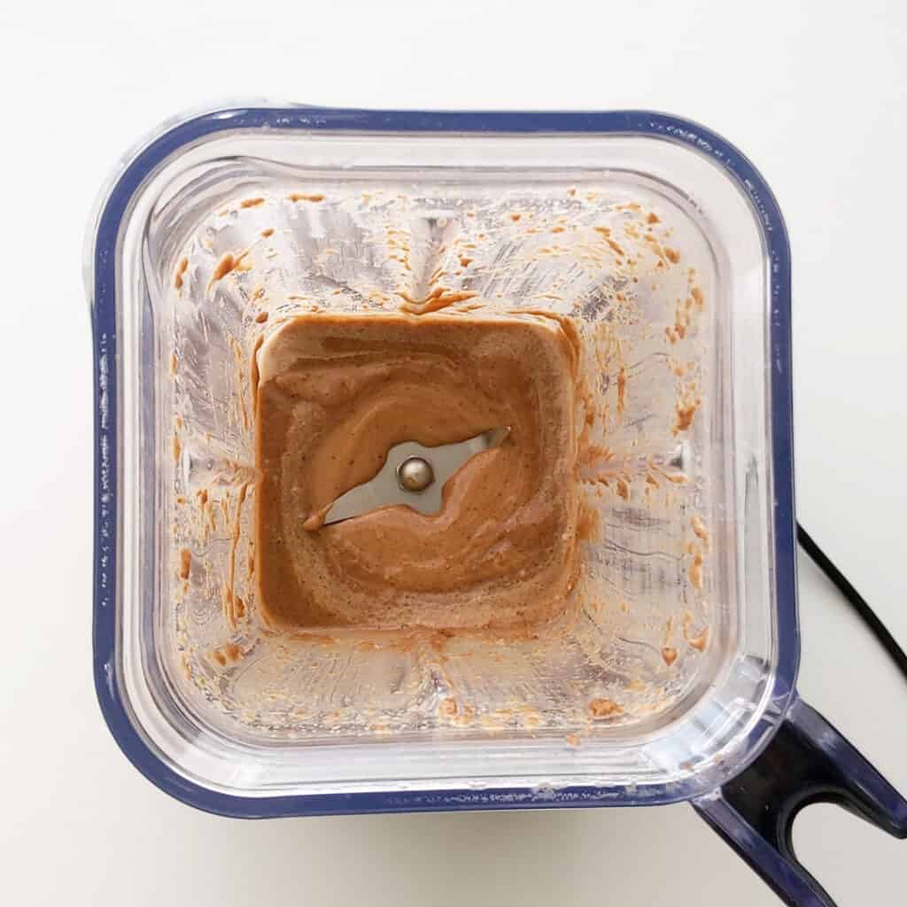 Fresh made cookie butter in the bottom of a blender.