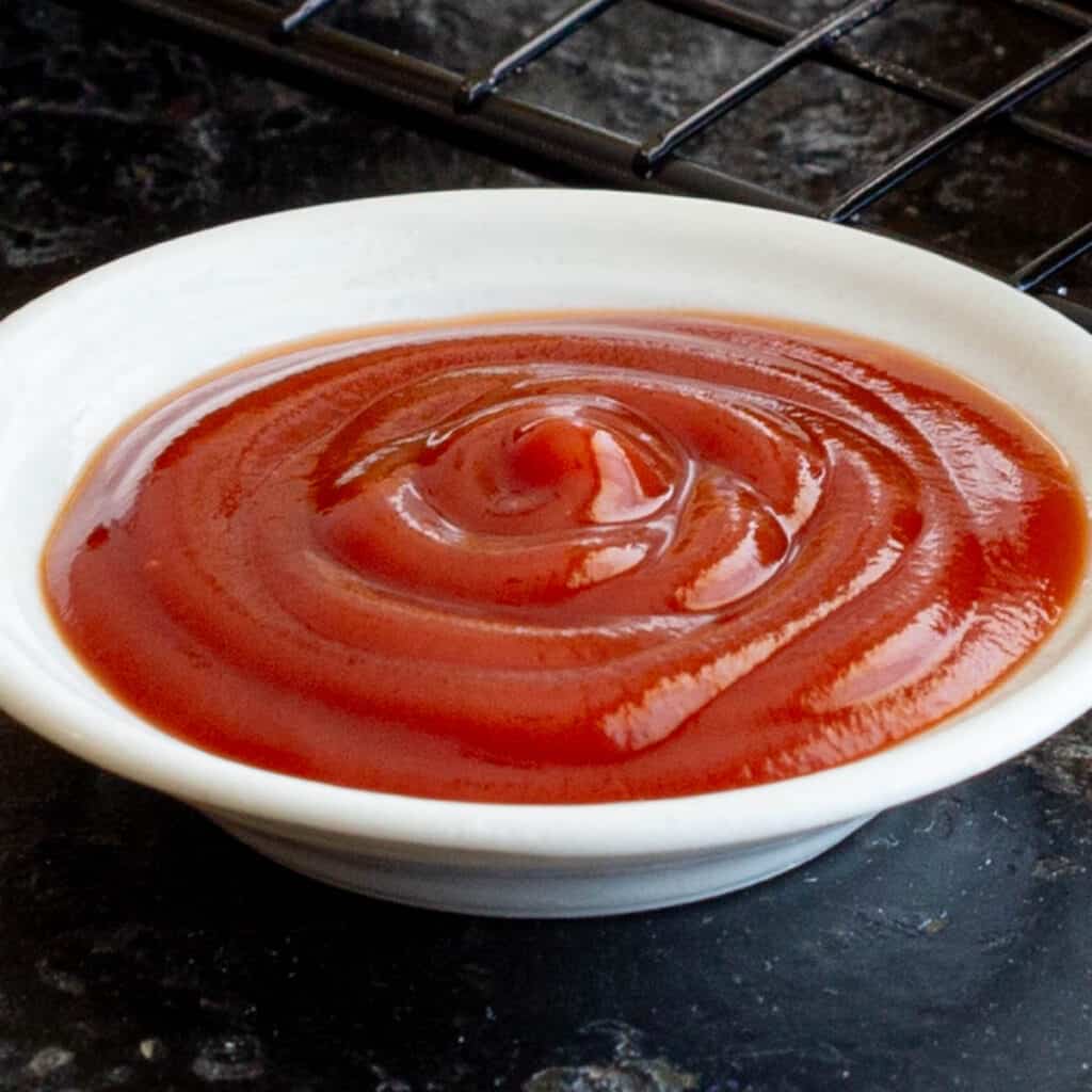 A small white dish filled with red tomato sauce.