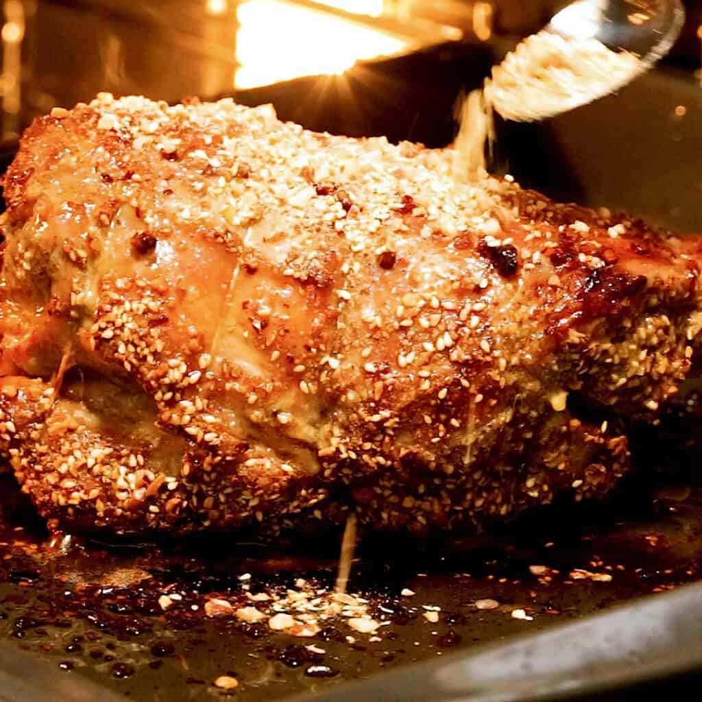 Dukkah is sprinkled over the top of a boneless lamb roast.