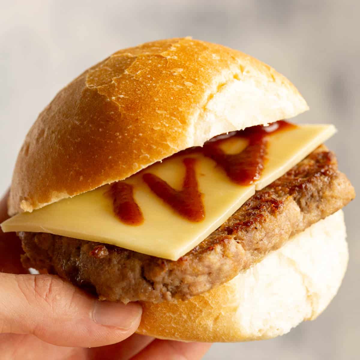 Square sausage in a breakfast bun with cheese and brown sauce.