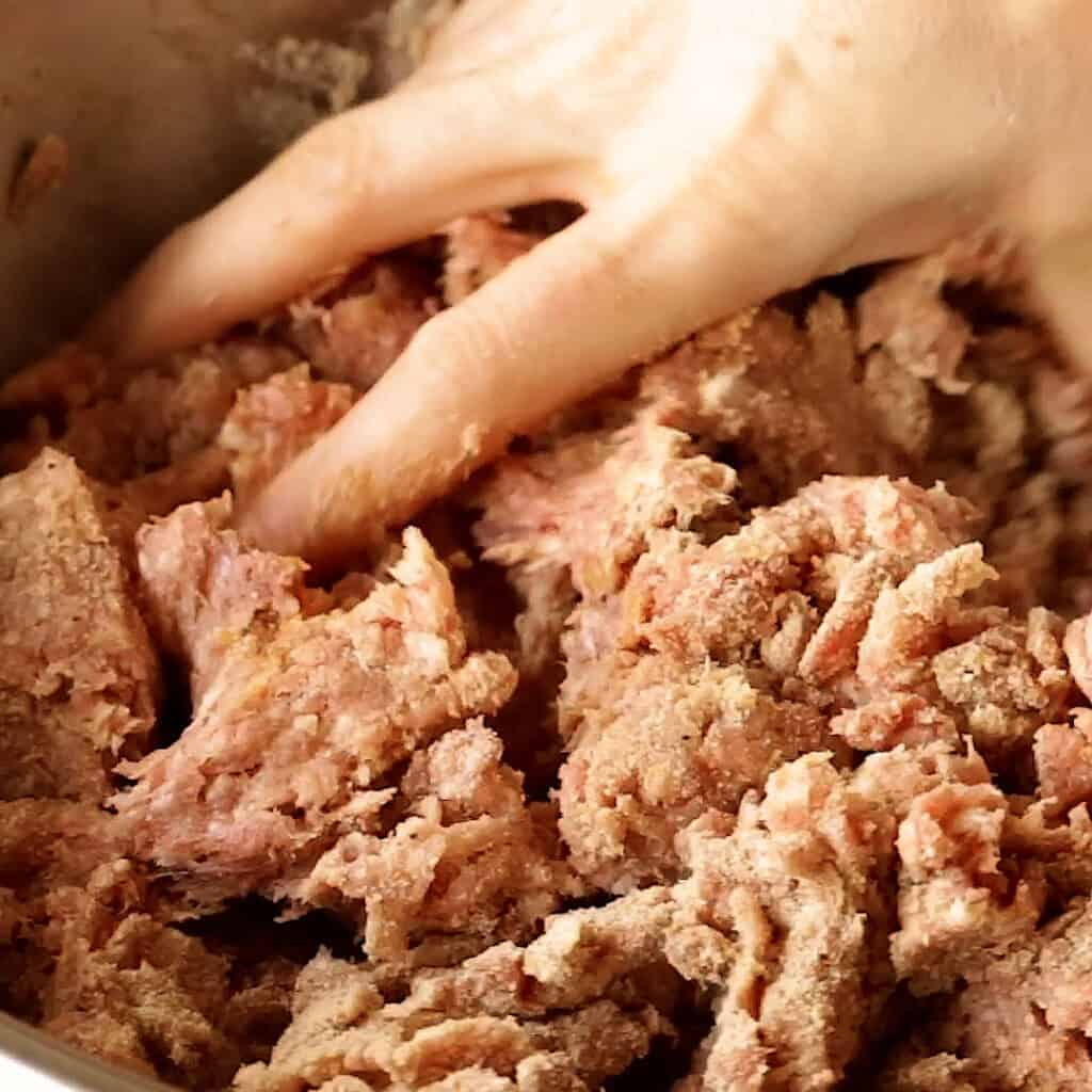 Kneading the mince meat together with the breadcrumbs.
