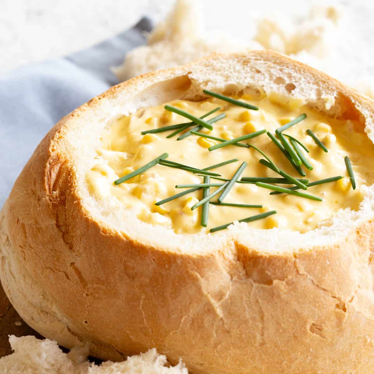 A bread bowl filled with chicken and corn dip.