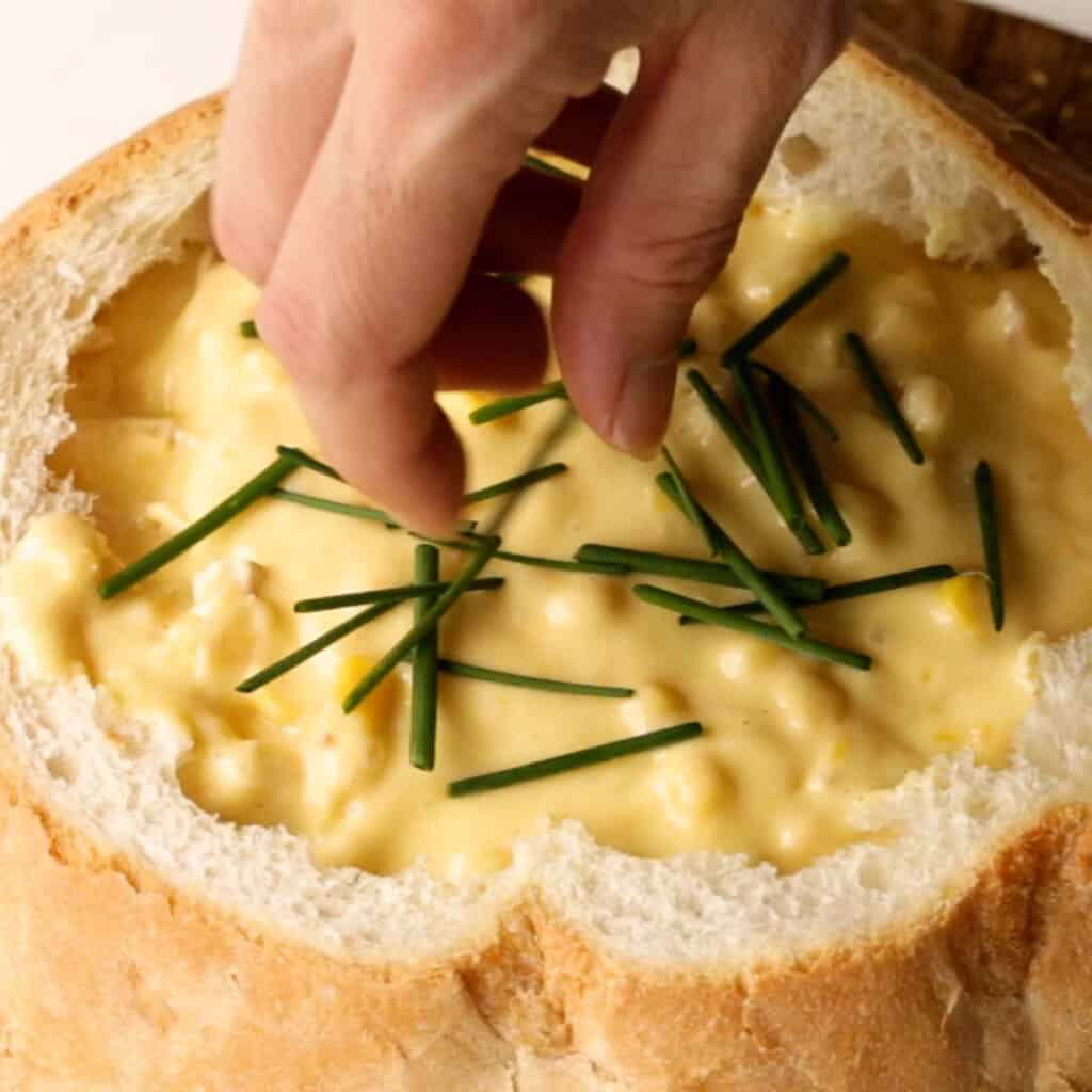 Garnishing the cob loaf with chives.