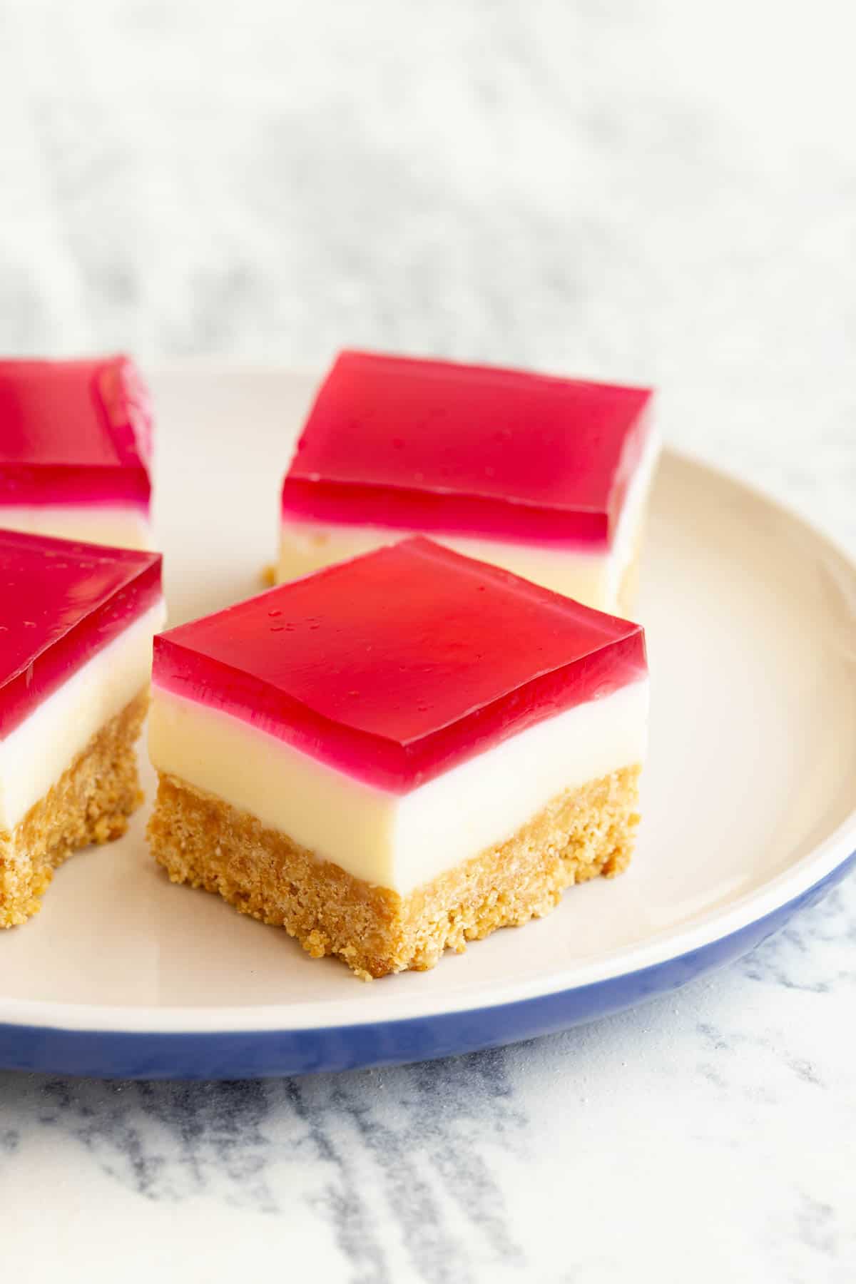 A plate of jelly slice bites, complete with red jelly topping.