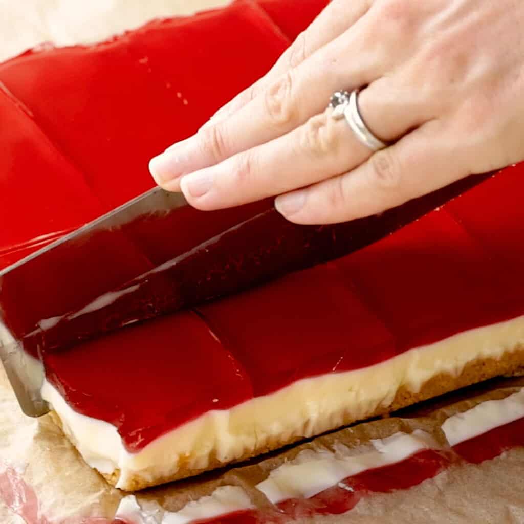 Slicing the jelly slice with a large knife.