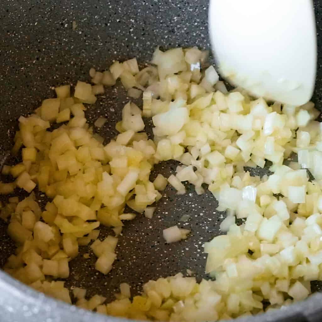 Frying onions in olive oil in a saucepan.