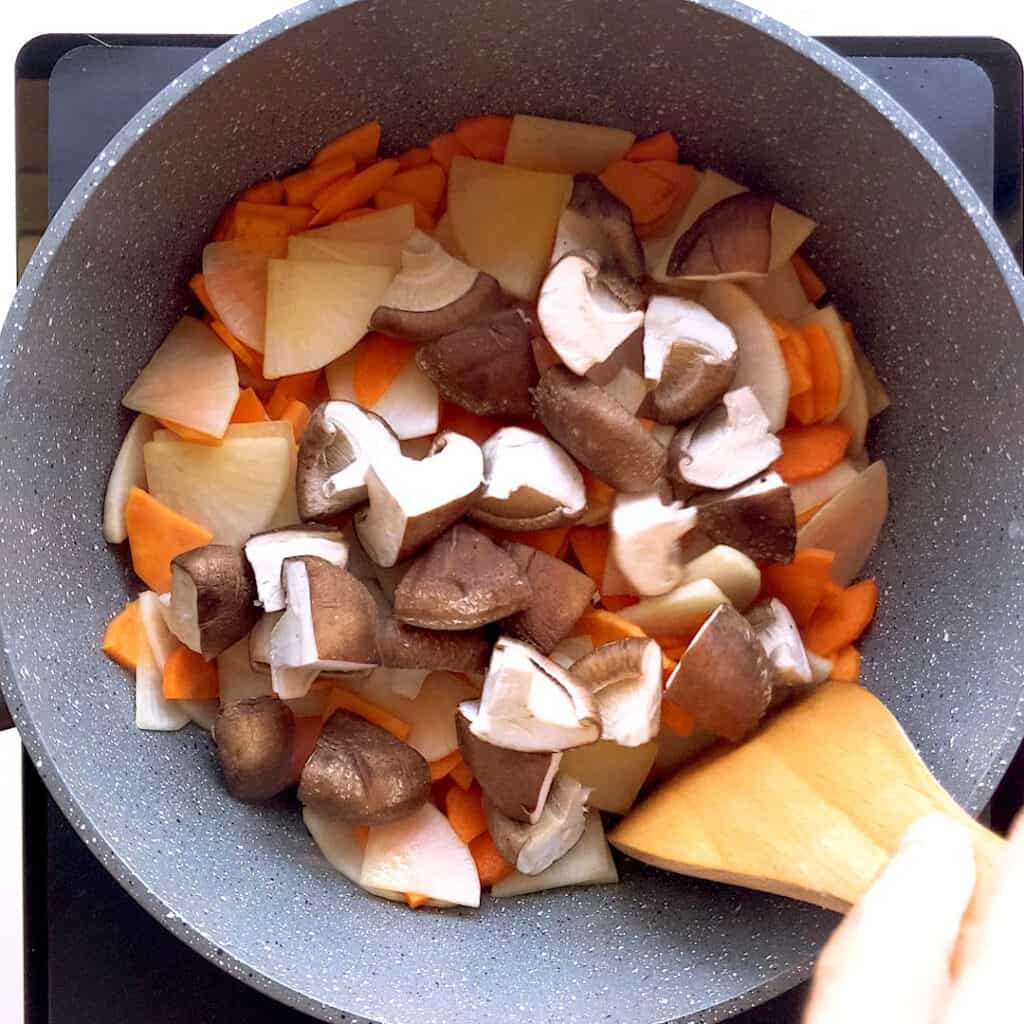 Frying vegetables in a saucepan in sesame oil.