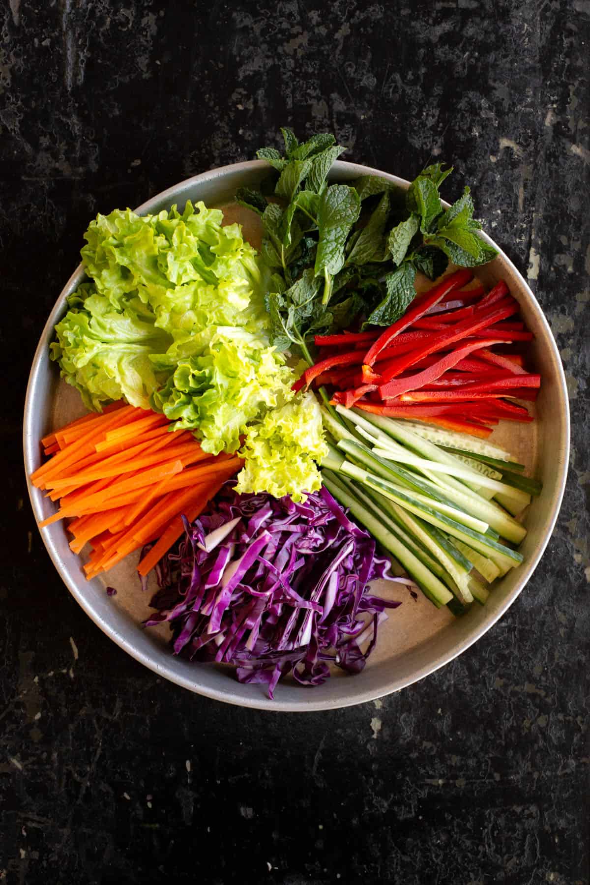 Tray of vegetables laid out in a rainbow wheel.