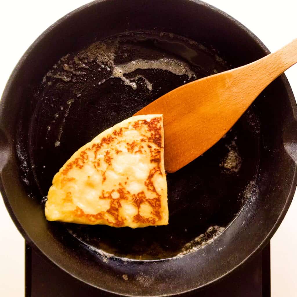 Frying a tattie scone in a cast iron pan.