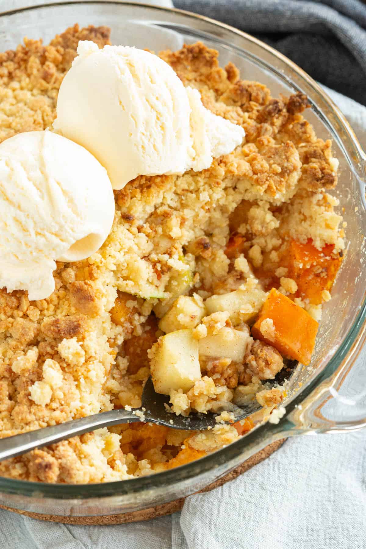A persimmon crumble topped with vanilla ice-cream.